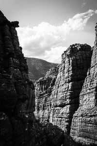 Rock formation on mountain against cloudy sky