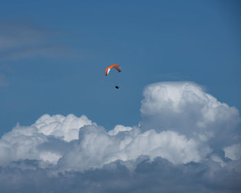 Low angle view of person paragliding against sky