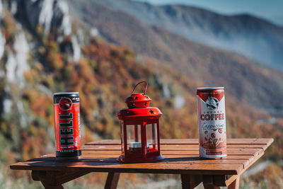 Close-up of drink on table against mountains