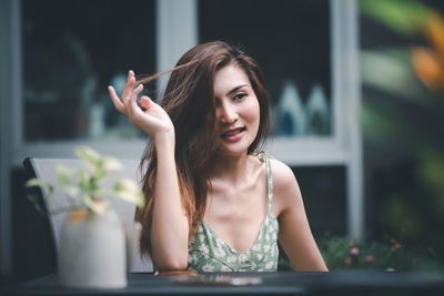 Portrait of a smiling young woman sitting outdoors