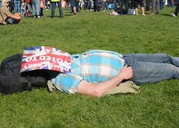 Low section of people lying on grass