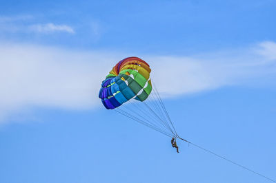 Low angle view of person paragliding against sky