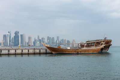 Boat in sea against buildings in city