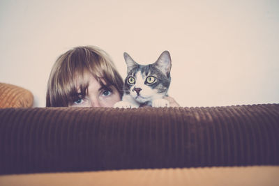 Portrait of woman with cat on sofa at home