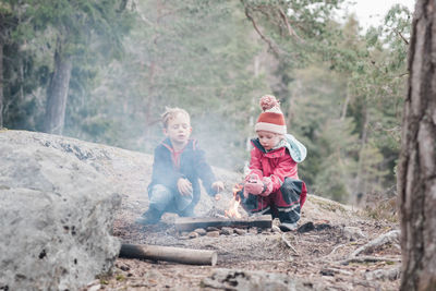 Siblings cooking marshmallows on a campfire in sweden