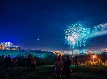 People watching firework display at night