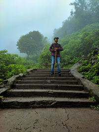 Man standing on staircase against sky