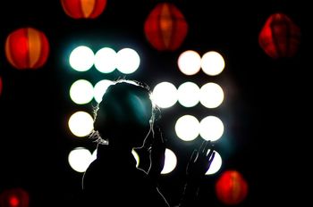 Silhouette woman against lanterns
