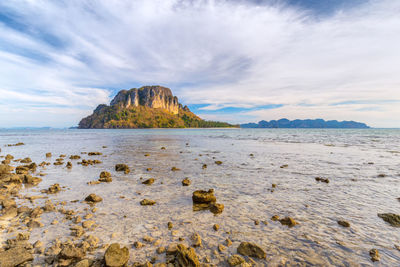 Rock formation on beach against sky