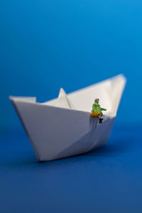 Close up of a origami paper ship with mini figure on it