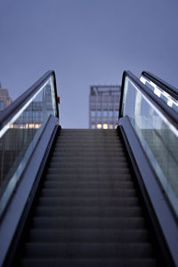 Low angle view of escalator against clear sky