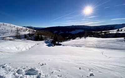 Scenic view of snow covered mountains against blue sky