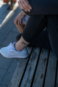 Low section of woman on wooden bench