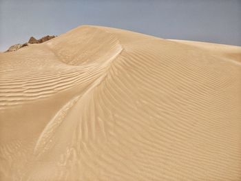 Sand dune in desert against sky