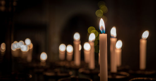 Close-up of illuminated candles in church