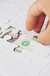 Cropped image of person solving jigsaw puzzles