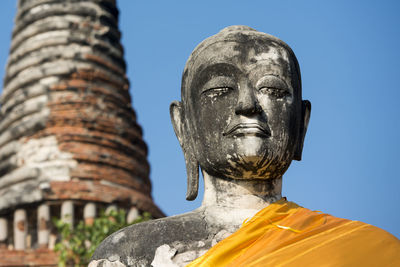 Low angle view of buddha statue at wat mahathat against clear sky