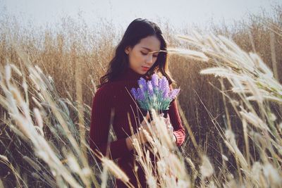 Beautiful young woman standing in field