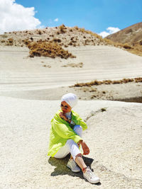 Full length of woman sitting on land