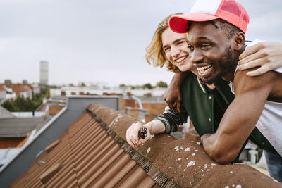 Male friends laughing while enjoying on rooftop