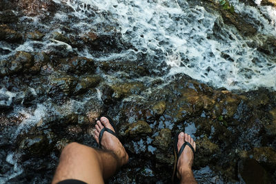 Low section of person on rocks in sea