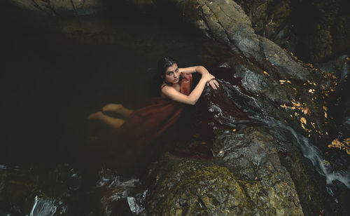 Portrait of young woman standing on rock