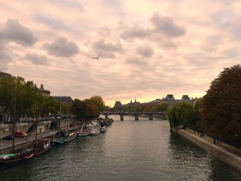 Bridge over river against cloudy sky