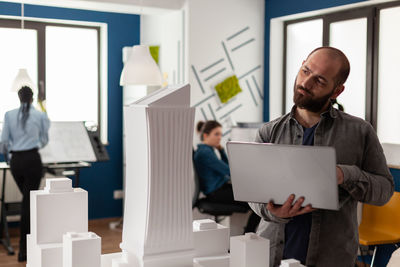 Midsection of man using digital tablet in office