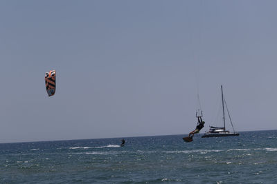 Sailboat sailing on sea against clear sky