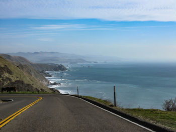 Road by sea against sky