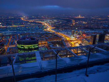 High angle view of illuminated cityscape against sky at night