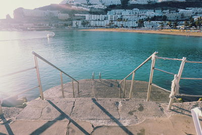 View of cityscape by sea against sky