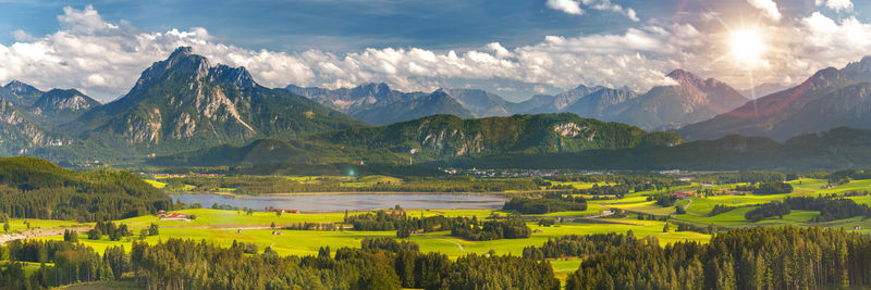 Panoramic landscape with mountain range and sun on sky