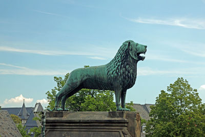 Low angle view of horse statue against sky