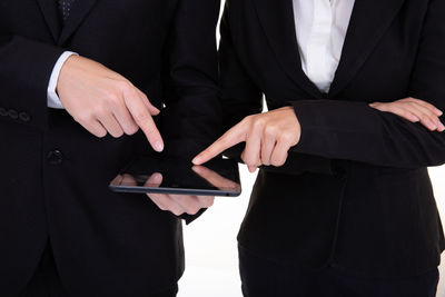 Midsection of colleagues using digital tablet in office