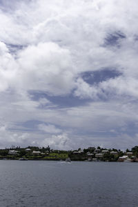 Scenic view of sea by buildings against sky