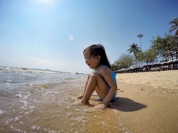 Full length of a young girl sitting on beach