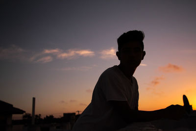 Silhouette man standing against sky during sunset