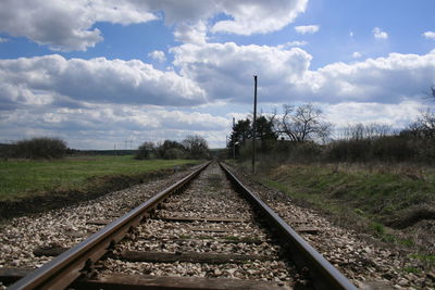 Railroad tracks amidst trees against sky