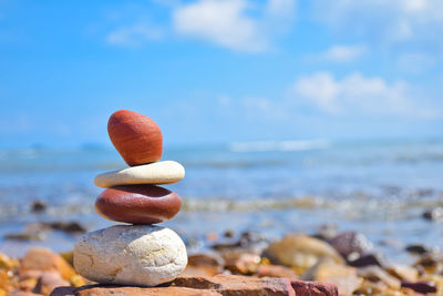 Close-up of pebbles in sea against sky