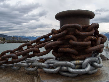 Close-up of rusty chain against sea