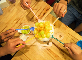 Cropped image of people having food at table