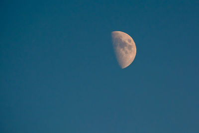 Low angle view of half moon against clear sky