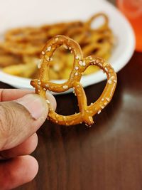 Close-up of hand holding pretzel