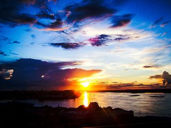 Scenic view of sea against dramatic sky during sunset