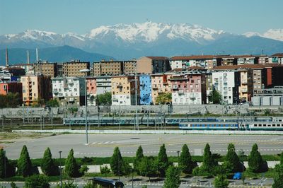 Buildings and railway area in city against sky