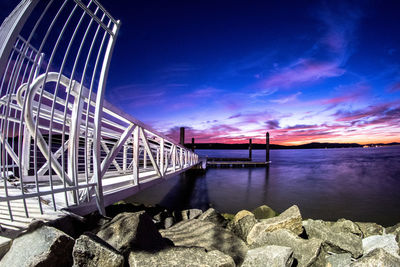 Bridge over river against cloudy sky