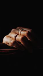 Close-up of woman hand over black background