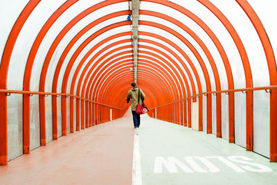 Rear view of man walking on footpath