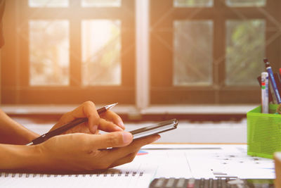 Cropped hand of woman using mobile phone